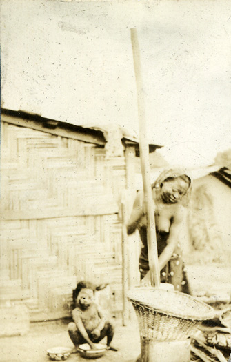 Photograph of woman grinding grain